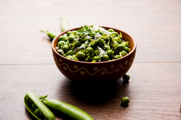 Green peas dry recipe or matar ki sookhi sabji, served in a serving pan or terracotta bowl. Selective focus