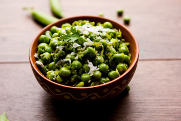 Green peas dry recipe or matar ki sookhi sabji, served in a serving pan or terracotta bowl. Selective focus