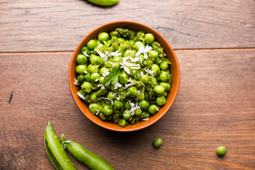 Green peas dry recipe or matar ki sookhi sabji, served in a serving pan or terracotta bowl. Selective focus