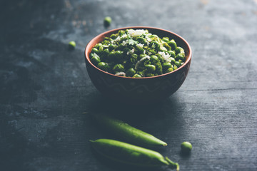 Green peas dry recipe or matar ki sookhi sabji, served in a serving pan or terracotta bowl. Selective focus