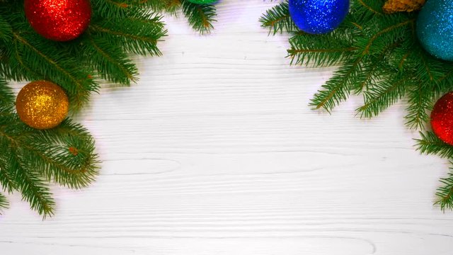 Beautiful holidays background of green spruce branches on white white wooden table decorated with christmas balls. Top view. Copy space. Happy new year 2019
