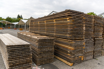 Messebau einer Regionalmesse, Zeltaufbau, Holzpfosten und Holzbretter für Zeltboden auf dem Stapel, im Hintergrund Zelte im Aufbau, Aluminiumprofile und weitere Elemente