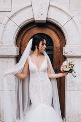 Bride in a white dress. Bride with a bouquet at the door of the castle. 