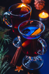 Festive mulled wine on the dark background.Holiday decorations, cones, pine twigs.