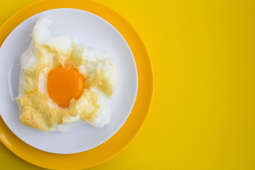 Egg in the cloud in  the colorful plates on the yellow  background.Top view.Copy space.Closeup.