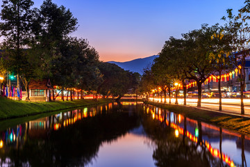 the light trails on the street at Chiang Mai Gate old city ancient wall and moat of the evening in Chiang Mai, Thailand.