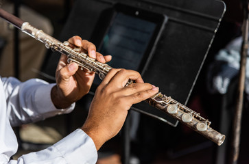 Young man plays the flute with a small orchestra during the Dickens Festival in Fayetteville, NC.