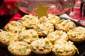 Tartlets with Salad Greens and filling. Snacks decorated with gold star for holiday
