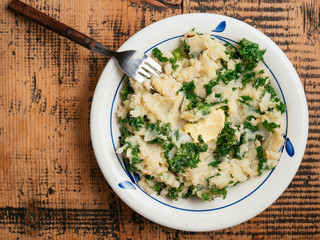 Freshly made colcannon on a plate. Ingredients: mashed potatoes, onion, kale, non-dairy milk, margarine, salt and pepper
