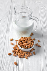 Healthy natural almond milk in glass jug with nuts for vegan and vegetarian