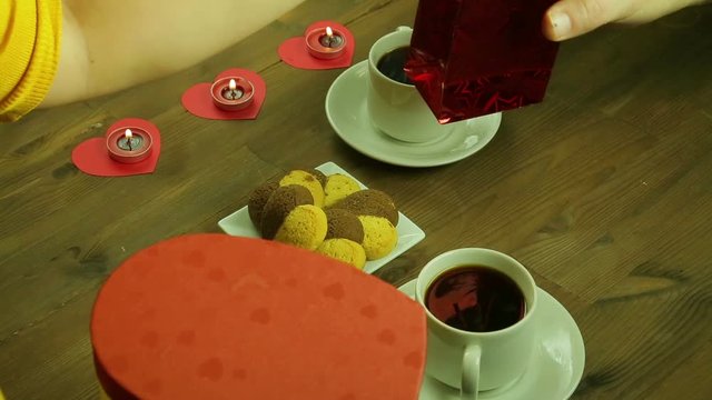 Young people in the cafe give each other gifts by candlelight.