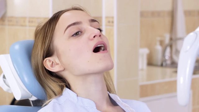 A girl in a dentist's chair with an open mouth