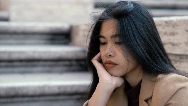 Depressed pensive young asian woman -outdoor