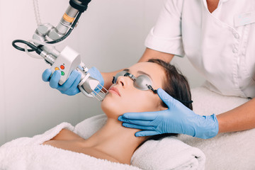 woman getting laser facial treatment, aesthetic surgery, - obrazy, fototapety, plakaty