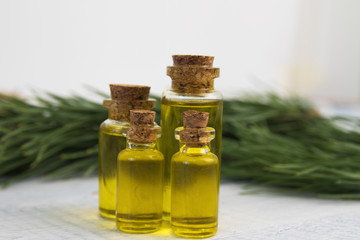 body oil in small jars on a background of pine branches