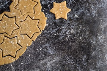 Raw christmas homemade gingerbread dough rolled out on dark table