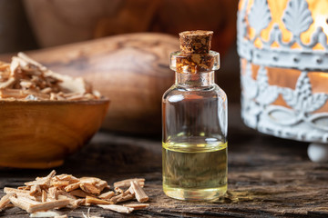 Fototapeta na wymiar A bottle of cedar essential oil with pieces of cedar wood