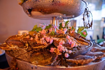 Tasty fresh oysters with flower decorate. Raw oysters are packed with nutrition, high in calcium, potassium, magnesium, vitamin and mineral. Flavor are sweet and refreshing. Believed to be aphrodisiac