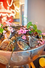 Tasty fresh oysters with flower decorate. Raw oysters are packed with nutrition, high in calcium, potassium, magnesium, vitamin and mineral. Flavor are sweet and refreshing. Believed to be aphrodisiac