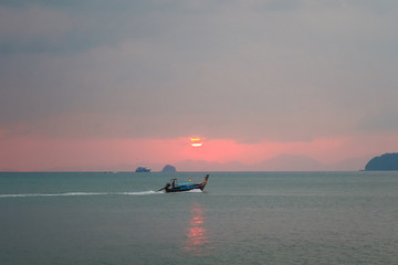 Fototapeta premium Beautiful sunset seascape with a boat in Thailand