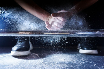 Athlete clapping hands with talc before deadlift barbells workout