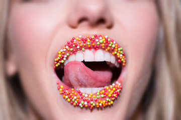 Sweet Lips. Female mouth decorated with candy. Compliments and sweet words. Beautiful mouth of...