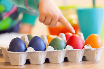 Mother and child painting eggs for Easter holidays