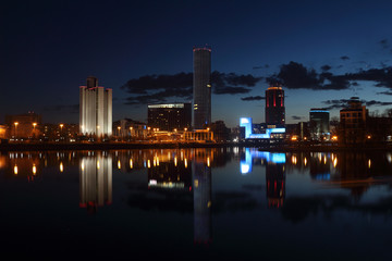 Obraz premium View over night modern city with skyscrapers by the river