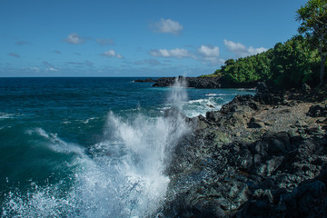 ocean waves crashing onto lava rocks