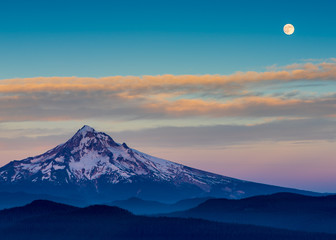 the full moon over a sunset landscape
