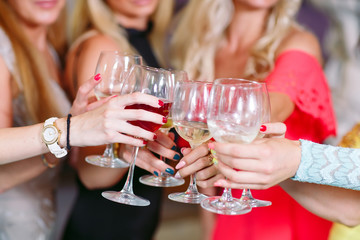 Hands holding glasses and toasting, happy festive moment.