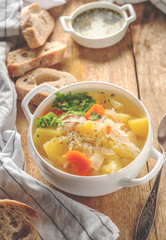 vegetable soup in a white plate on a wooden table, copy space