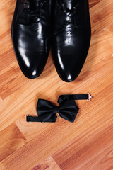 top view of stylish black men's shoes and black bow tie