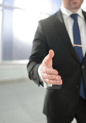 businessman holding out his hand for a handshake