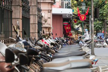 scooters and communist propaganda symbol in Hanoi, Vietnam