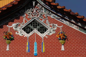 Attractive brick facade decoration showing flowers and cords and wavy ornaments in a buddhist temple downtown Taichung city, Taiwan, China, Asia
