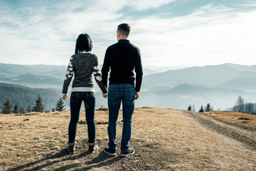 the guy with the girl stand in the mountains
