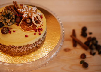 Christmas cake with oranges and nuts on a wooden background. Raw dessert
