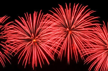 Flashes of red fireworks on a black background