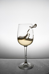 splash of white wine in a glass