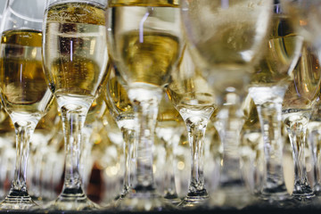 Sommelier pours champagne from a bottle into a glass at the table in the restaurant.