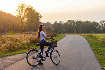 Active woman riding bicycle at autumn day