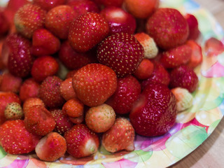 Plenty of strawberries in the plate at the  table