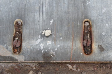 metal grate with large rusted screws