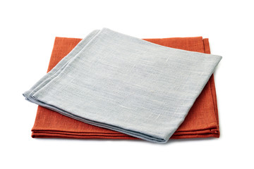 Folded gray and brown textile napkins stacked on white background