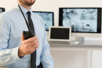 Male security guard with portable transmitter indoors, closeup