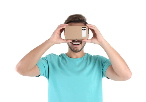 Young man using cardboard virtual reality headset, isolated on white