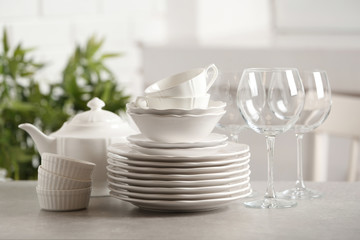 Fototapeta na wymiar Set of clean dishes on table against blurred background