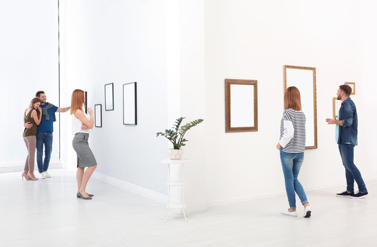 People viewing exposition in modern art gallery