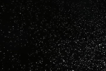 Snow flakes falling on black background. Winter weather